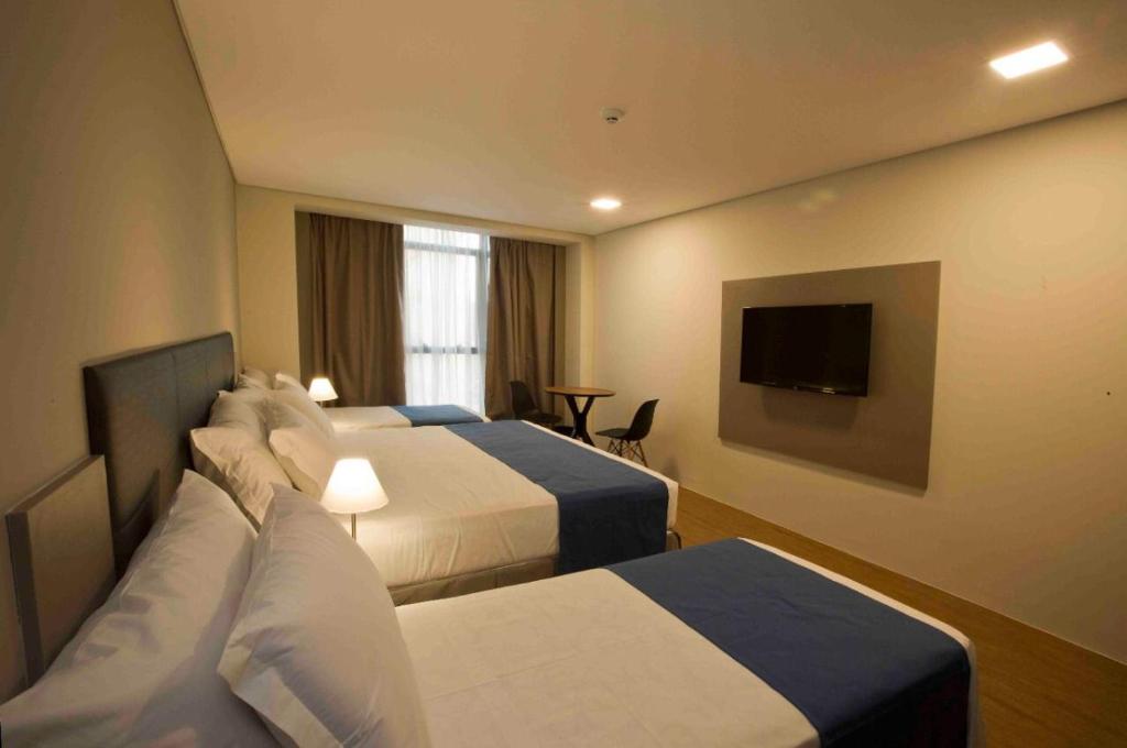 累西腓Fity Hotel的酒店客房设有两张床和一台平面电视。