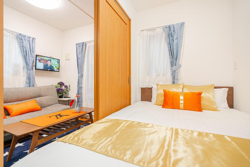 东京KYARA HOTEL　亀戸501的一间带床和沙发的小卧室
