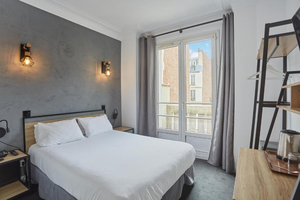 巴黎奥古斯特酒店 的一间卧室设有一张床和一个大窗户