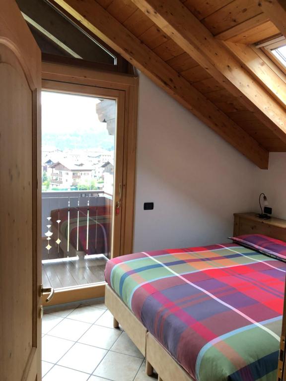 博尔米奥萨布罗尼拉公寓式酒店的一间卧室设有一张床和一个大窗户