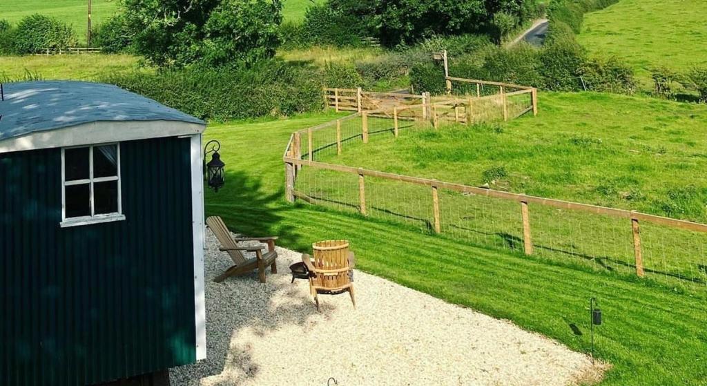 AstburyPeggy’s Hut的一个带长凳和围栏的小棚子