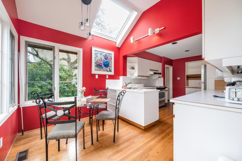 温哥华Tranquil Haven near Attractions 2BD Upper Floor or 2BD Basement Floor的厨房设有红色的墙壁和桌椅