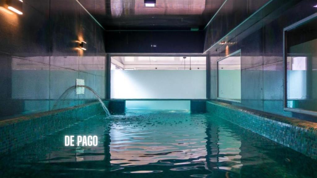 埃斯特角城布拉瓦海滩酒店的一座有水池的建筑中的水池