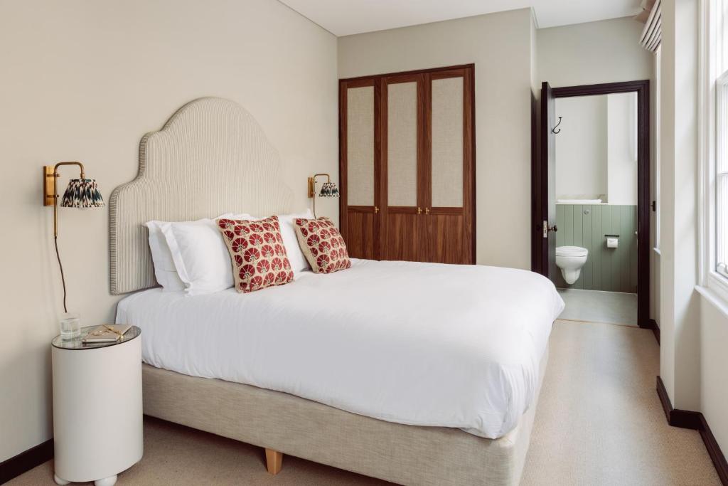 伦敦Native Kings Wardrobe的卧室配有带红色枕头的大型白色床