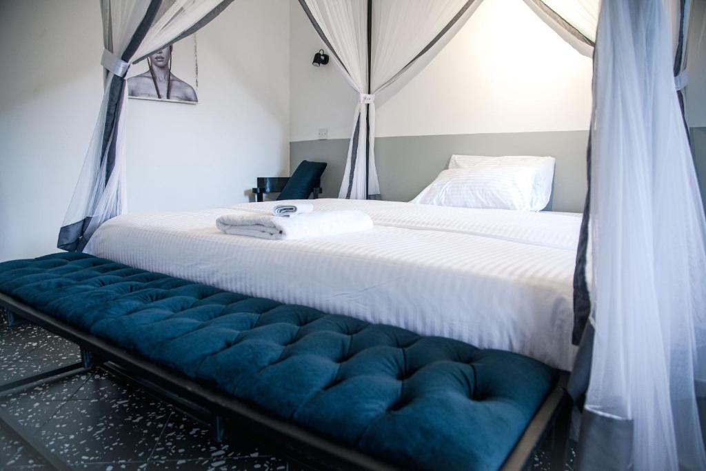 坎帕拉Explorers Hub的一间卧室配有一张大床和蓝色长凳
