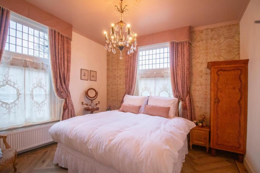 德斯泰赫Hotellerie Het Wapen Van Athlone的卧室设有白色大床和窗户。