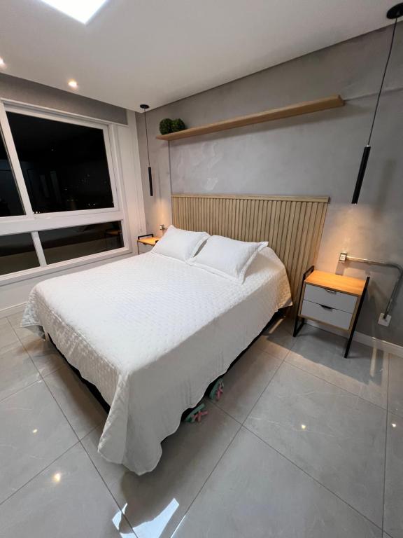 新汉堡市Apartamento/Studio Novo Hamburgo的卧室设有一张白色大床和一扇窗户。