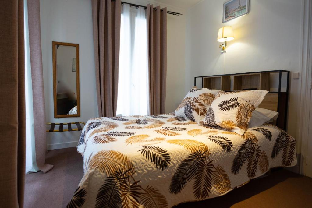 巴黎理想酒店的一间卧室配有一张床和被子