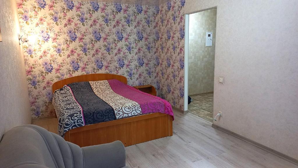 敖德萨Apartment - Generala Petrova Street的一间卧室配有一张带花卉壁纸的床