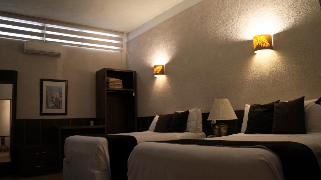 Fresnillo de González EcheverríaHotel Casa Blanca的酒店客房,设有两张床,墙上有灯