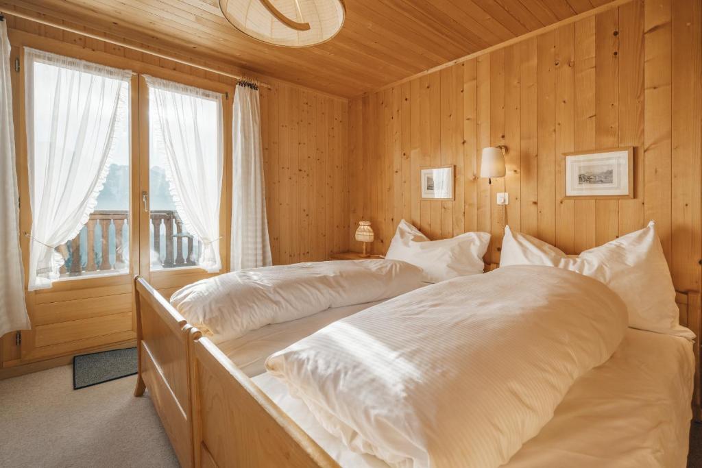 艾姆敦Chalet Engihalde的一间卧室设有两张床和窗户。