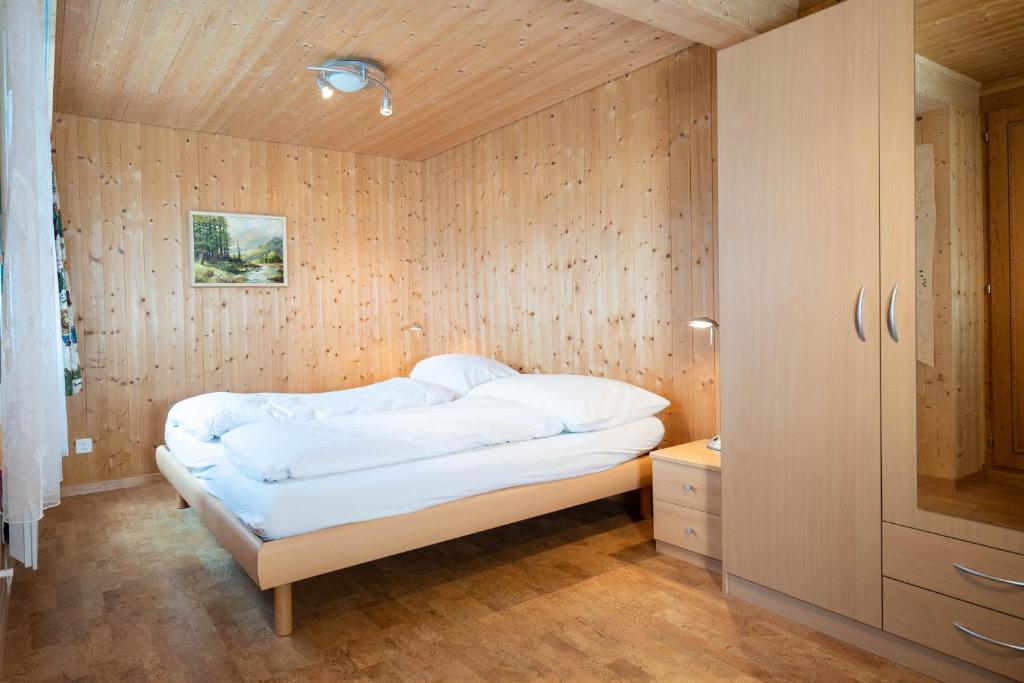 艾姆敦Chalet Chapfwald的木墙客房的一张床位