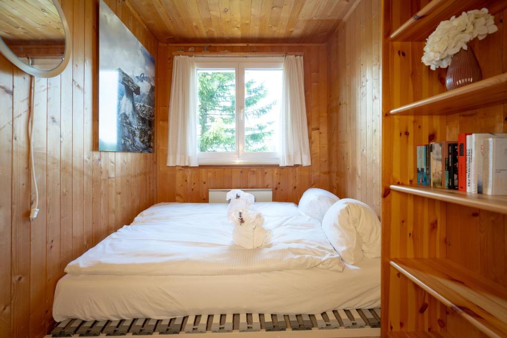 艾姆敦Chalet Sönderli的木制客房的一张床位,设有窗户
