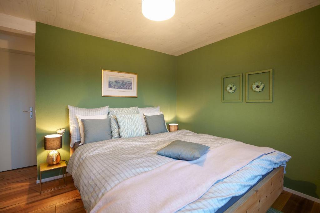 艾姆敦Chalet Fridolin的一间卧室设有一张带绿色墙壁的大床