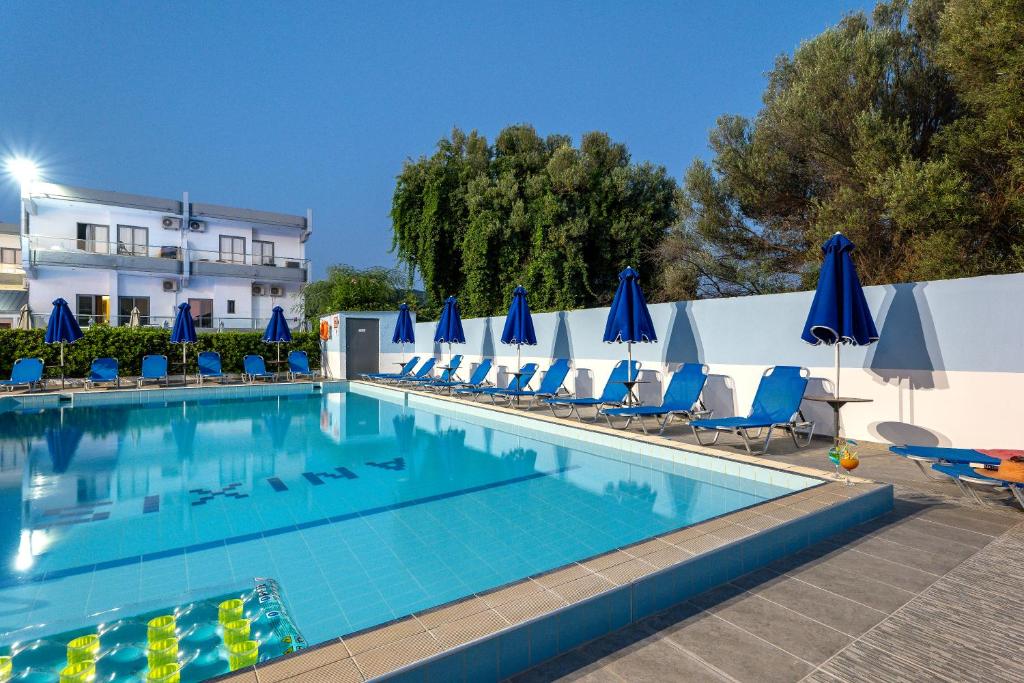 伊利索斯Anixis Hotel & Apartments的一个带椅子和蓝伞的游泳池