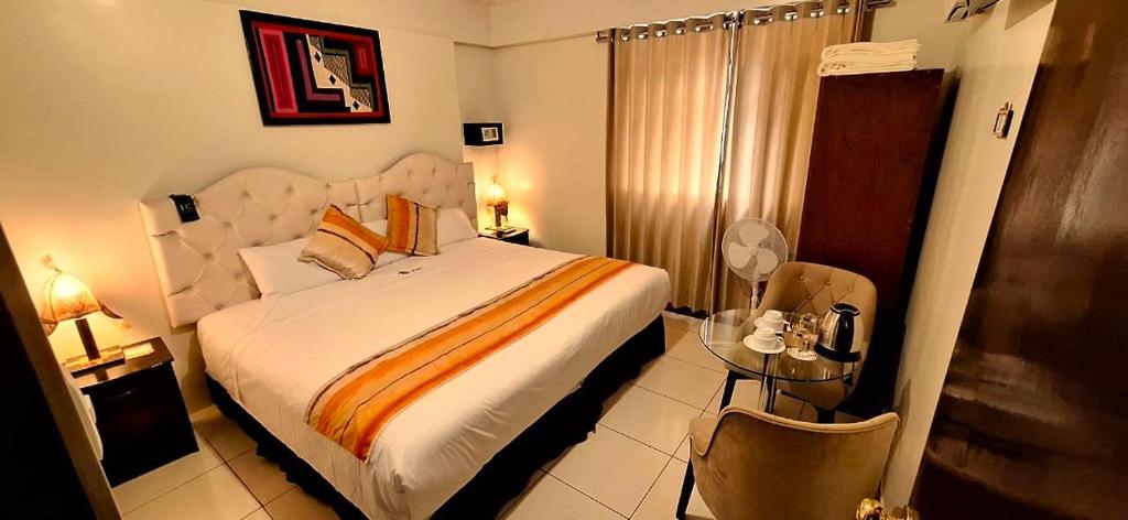 马丘比丘ANDINO HOTEL MACHUPICCHu的一间卧室设有一张大床和一张玻璃桌