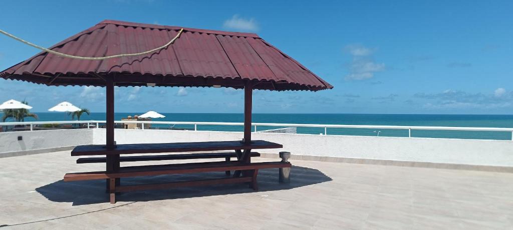 纳塔尔Beira-Mar flat 310 Ponta Negra Beach的海滩上带红伞的长凳