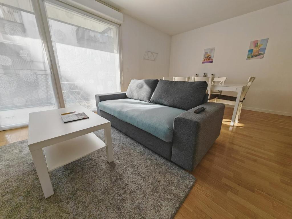 圣吉欧梅斯Paris 15 min Appartement tout confort 6 couchages的客厅配有沙发和桌子