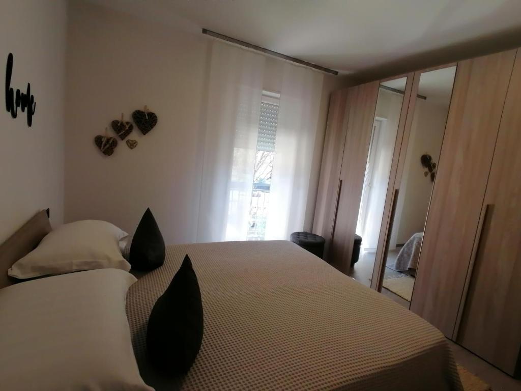 阿科Appartamento Meridiana的一间卧室配有一张带黑色枕头的床和一扇窗户。