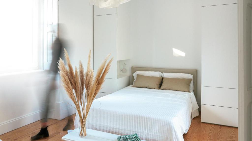 阿布兰特什Casa Napperon的一间白色卧室,配有床和植物