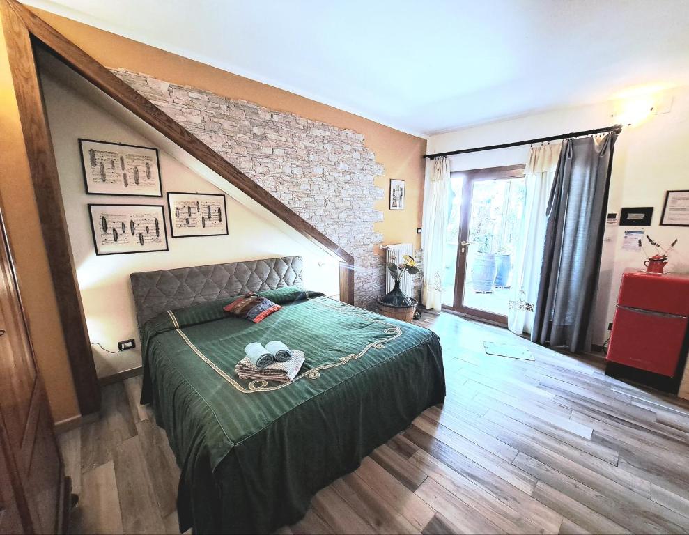 比森齐奥营MARCONI DEPENDANCE的一间卧室配有一张带绿色棉被的床