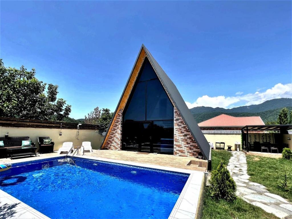 盖贝莱Gabala Twin A Frame Villas的一座带三角形屋顶游泳池的房子