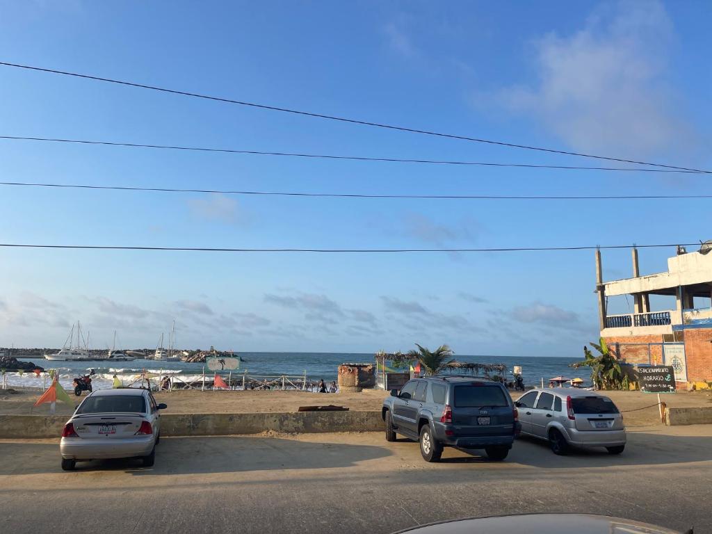 Catia La MarHotel brisas del mar 2022的三辆车停在海滩附近的停车场