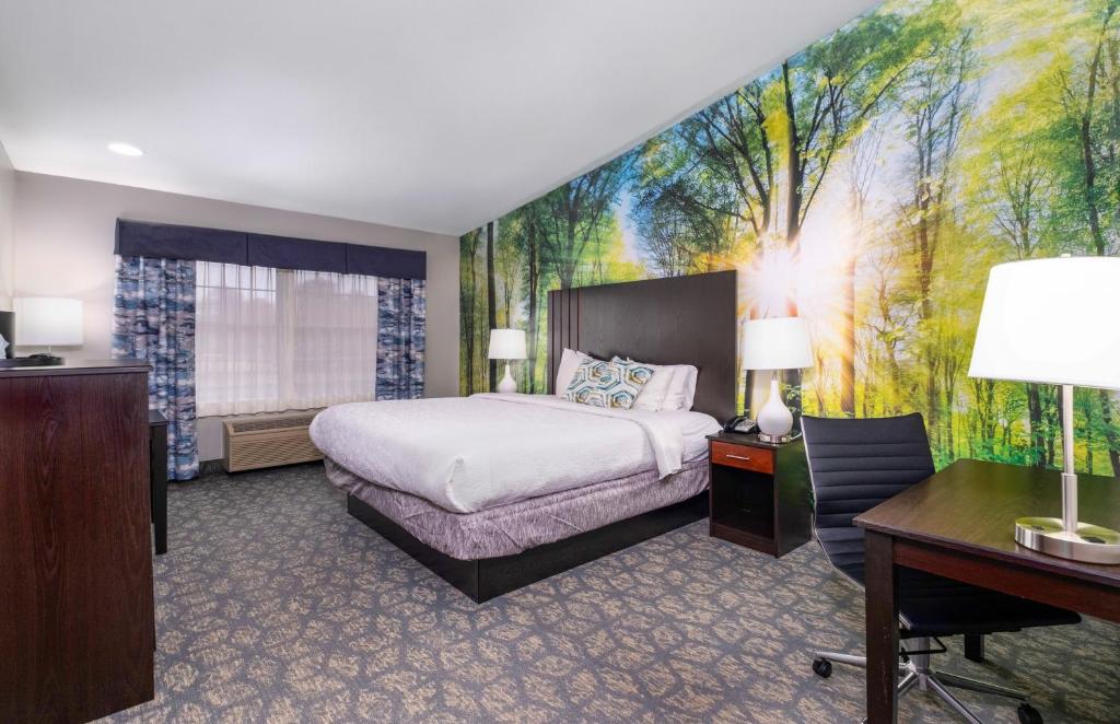 弗里波特Casco Bay Inn的卧室配有一张床,墙上挂有绘画作品