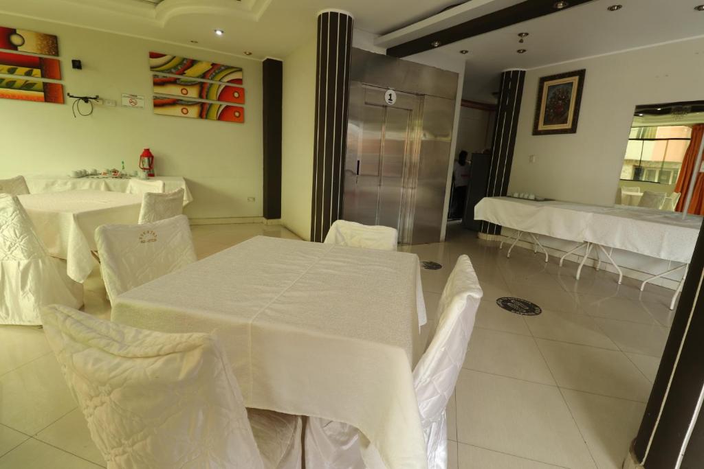 塔克纳Hotel Frontera的用餐室配有白色的桌子和白色的椅子