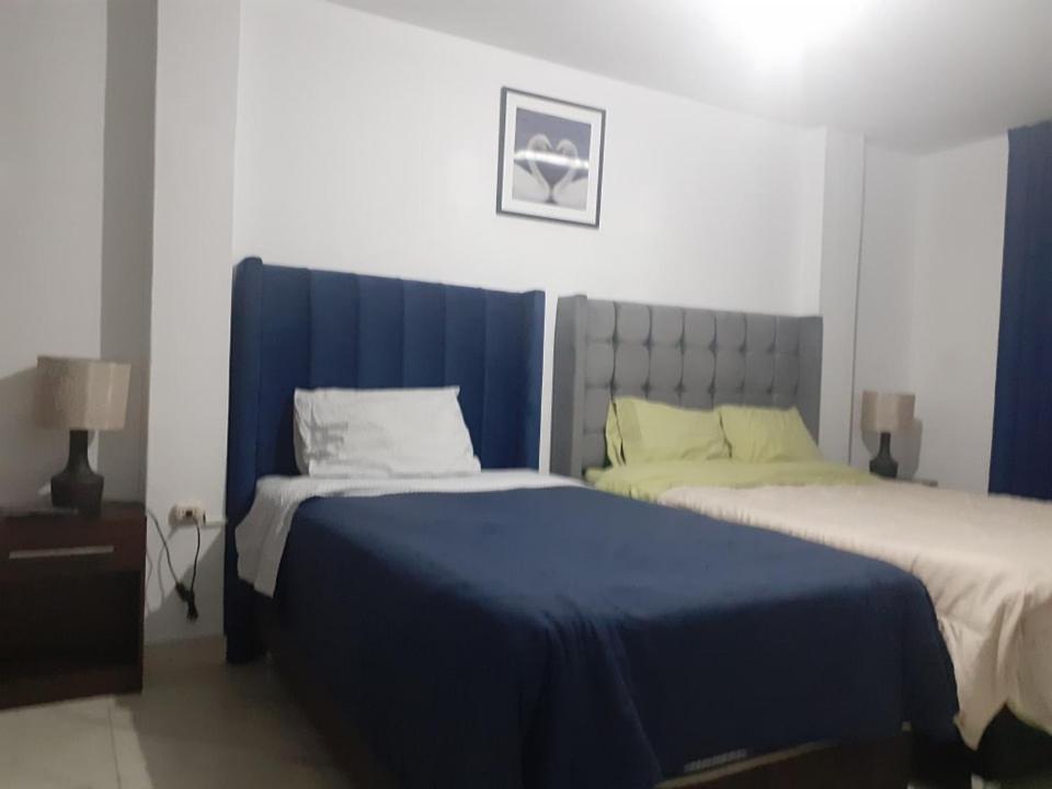 卡哈马卡Casa-Posada的一间卧室配有两张带蓝白色床单的床