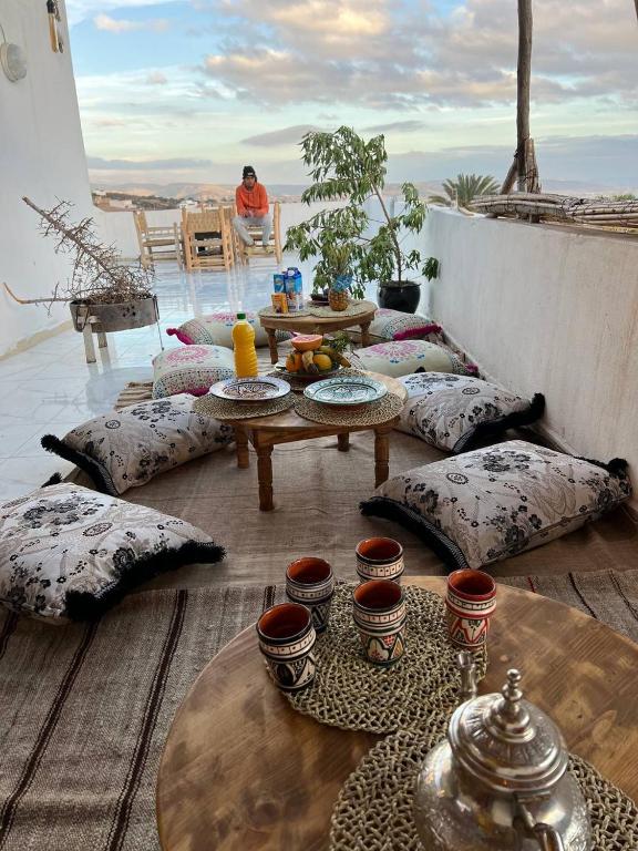 阿加迪尔rise surf and yoga morocco的阳台上配有桌子和枕头,配有桌子