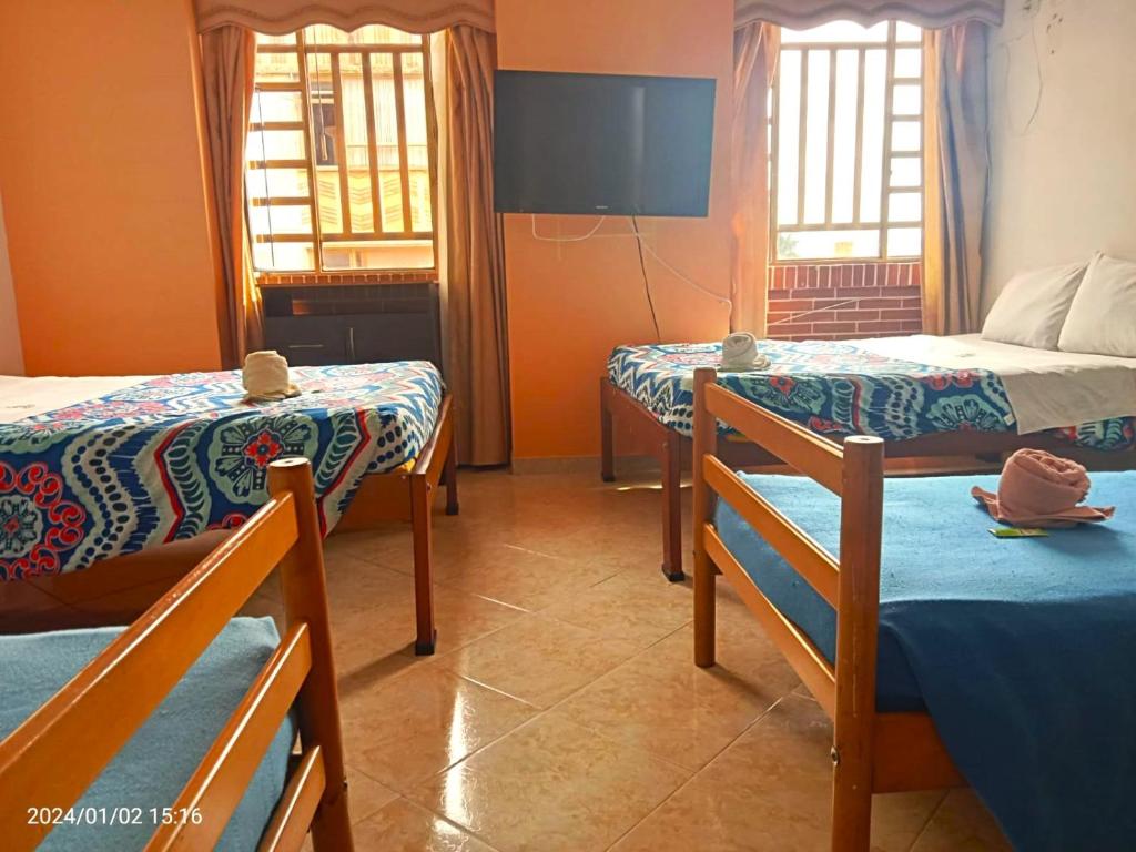 富萨加苏加Hotel Dorado Real的带三张床和两扇窗户的房间