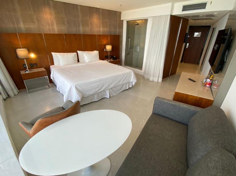 里约热内卢Apart Hotel的酒店客房带一张床、一张桌子和椅子