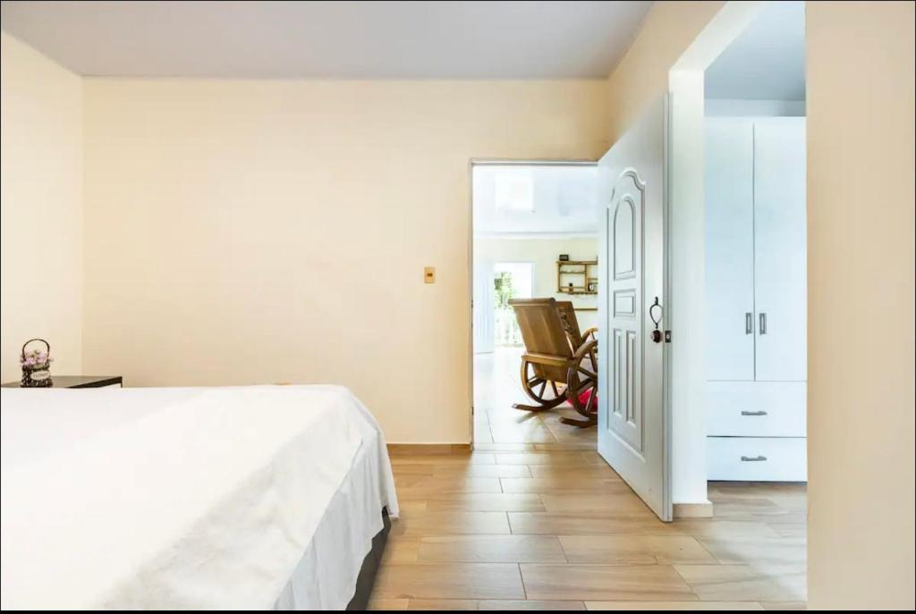 里奥圣胡安apartamento EL CORAL的卧室配有白色的床和椅子