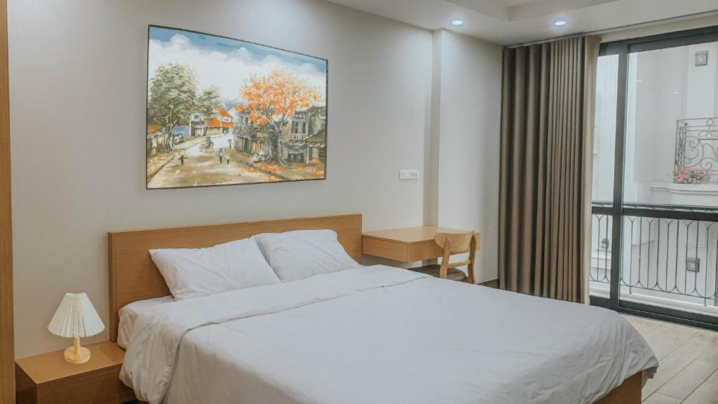 河内Yen’s House的卧室配有一张床,墙上挂有绘画作品