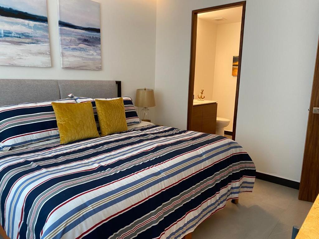 巴亚尔塔港Casa Cielo Vallarta V-Golf的一间卧室配有一张带黄色枕头的大床