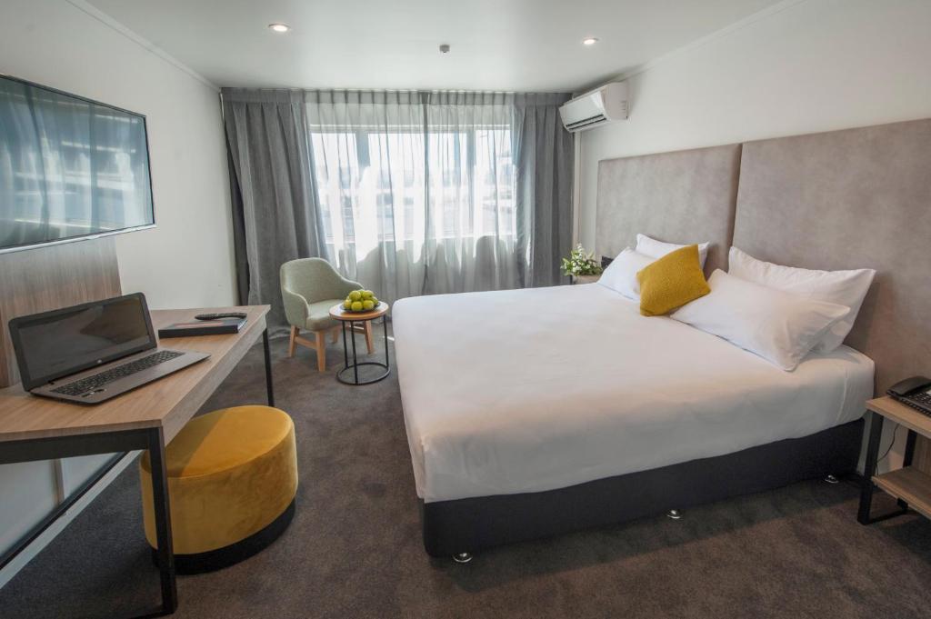 罗托鲁瓦苏迪马酒店的酒店客房配有一张床、一张书桌和一台笔记本电脑