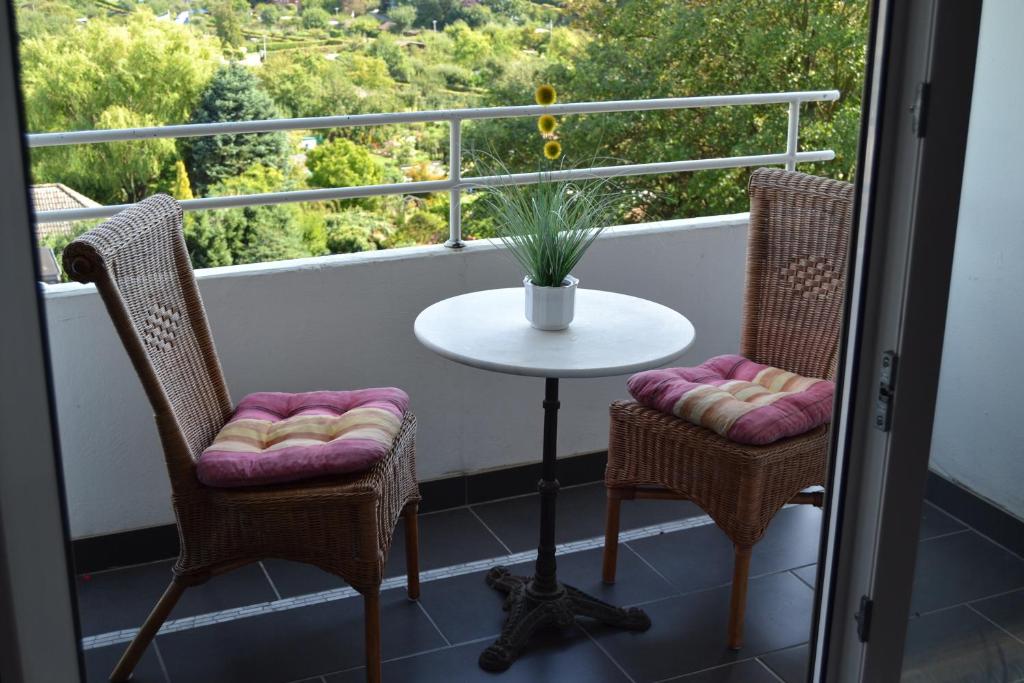 希尔德斯海姆艾姆斯坦伯格公寓的阳台配有桌子、两把椅子和一张桌子。