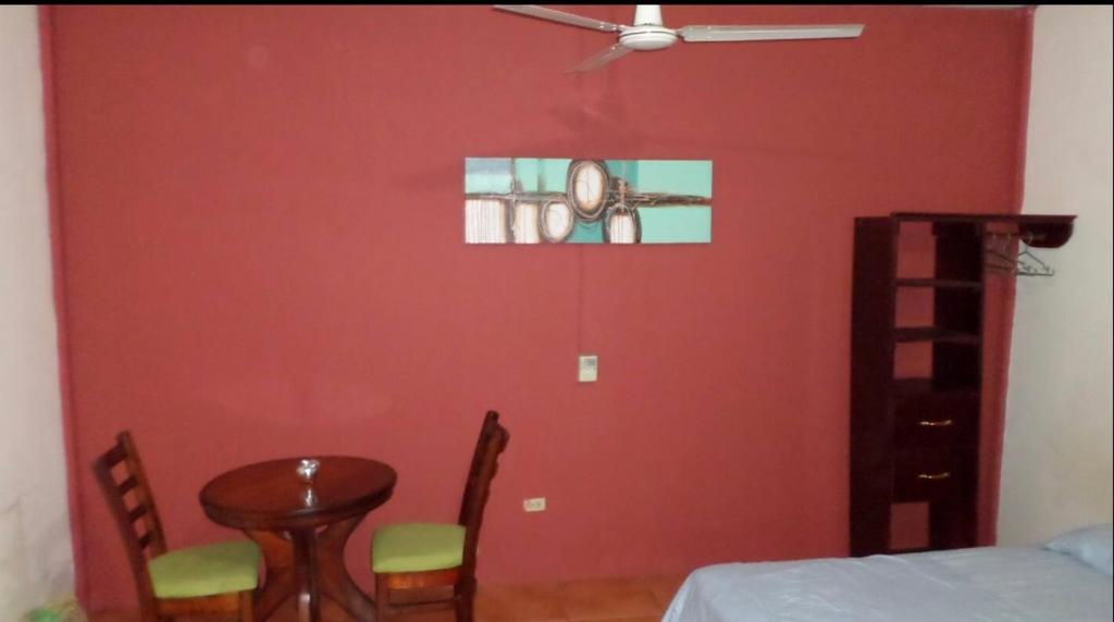 马那瓜31 ave home stay的一间设有红色墙壁、桌子和椅子的房间