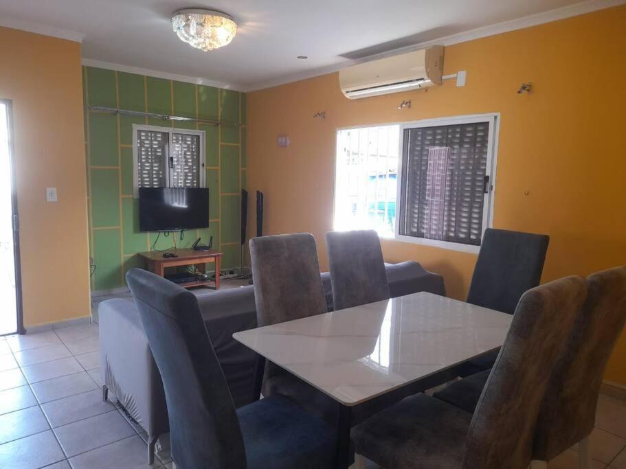 罗安达Casa de Amor的一间带桌椅和电视的用餐室