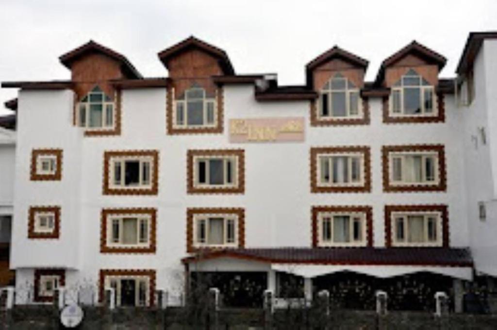 斯利那加HOTEL K2 INN , Srinagar的白色的大建筑,设有棕色和白色的窗户