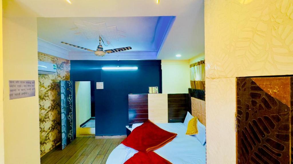 乌贾因New G P Guest house的一间卧室配有红色和黄色枕头的床