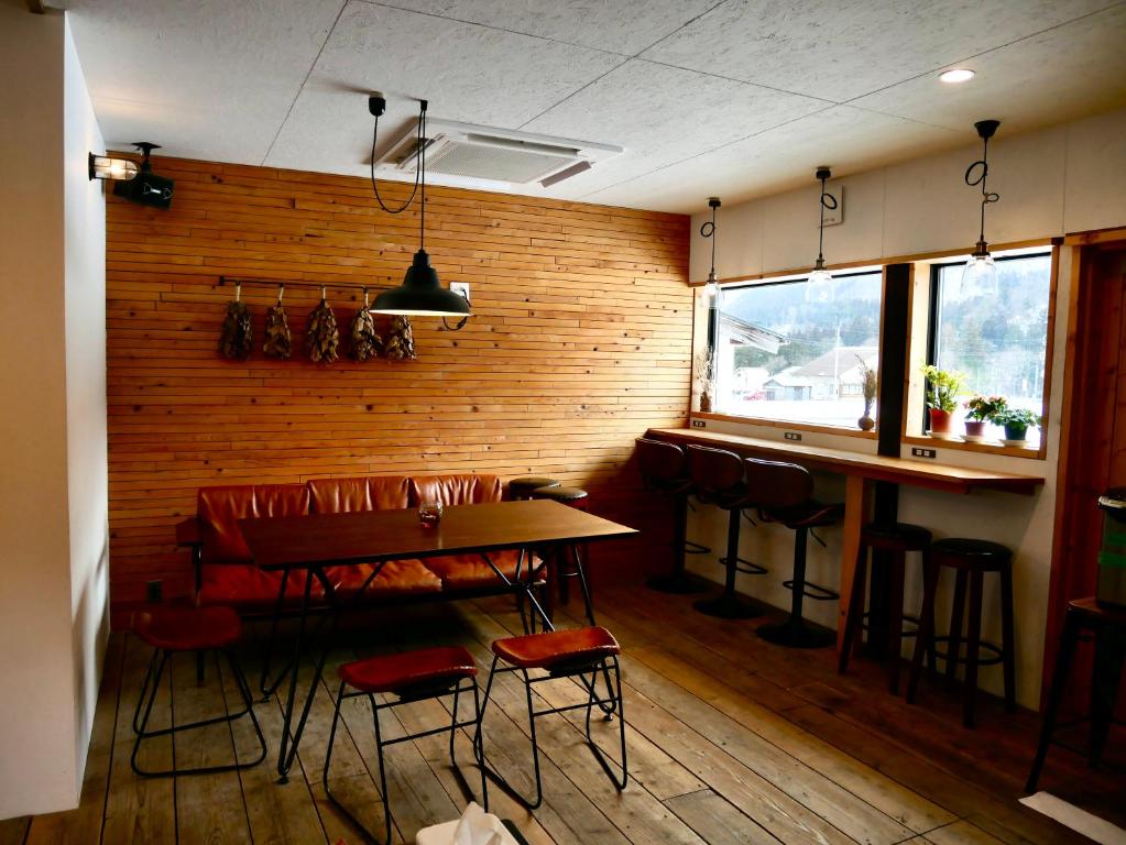 白川村GuestHouse Shirakawa-Go INN的一间带桌椅的餐厅和酒吧