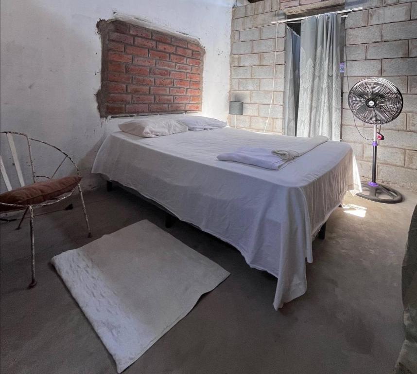 里瓦斯Hostal Brisas del Ometepe的一间卧室设有一张床和砖墙