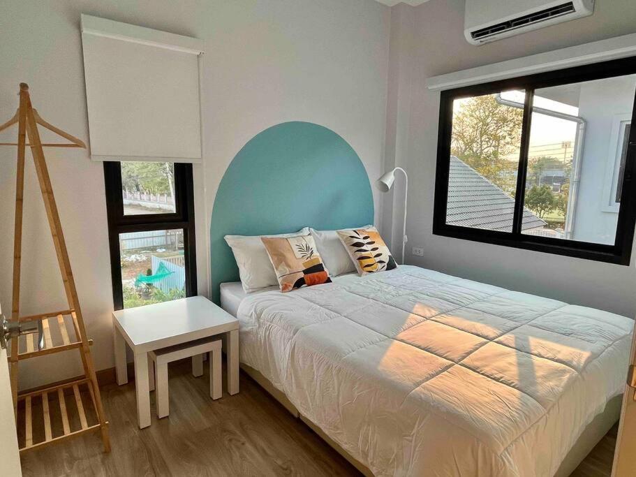 清莱Borbaimai home的一间卧室设有一张床和一个大窗户