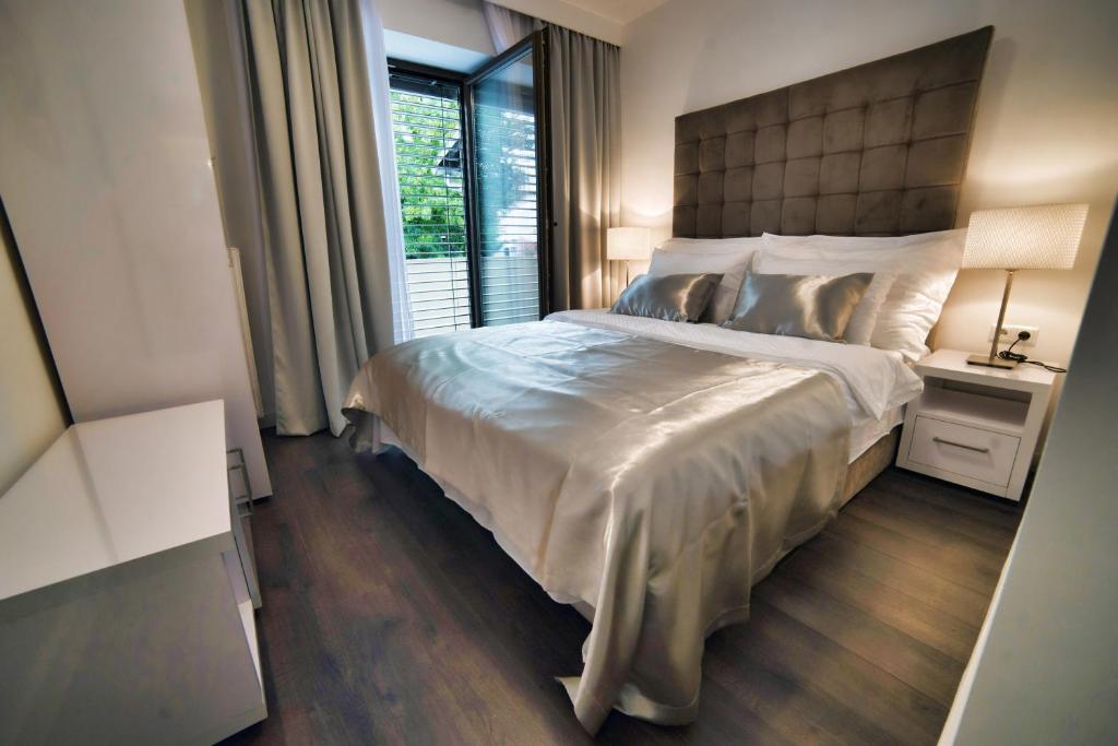 萨格勒布Casa V Luxury Apartments的一间卧室设有一张大床和一个窗户。