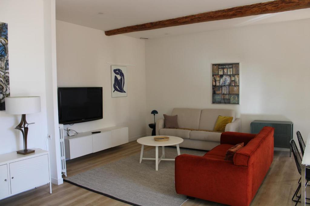 尼姆Maison chaleureuse avec grande terrasse的客厅配有红色沙发和电视