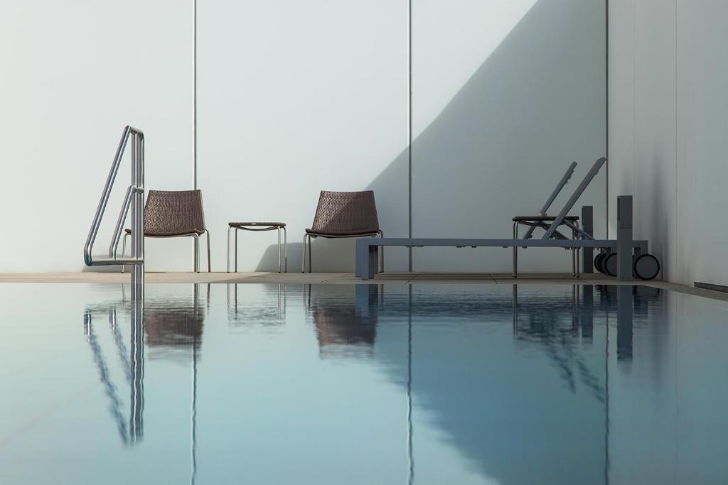 多瑙河畔克雷姆斯卡灵扈巴酒店的一个带椅子的房间和一个游泳池