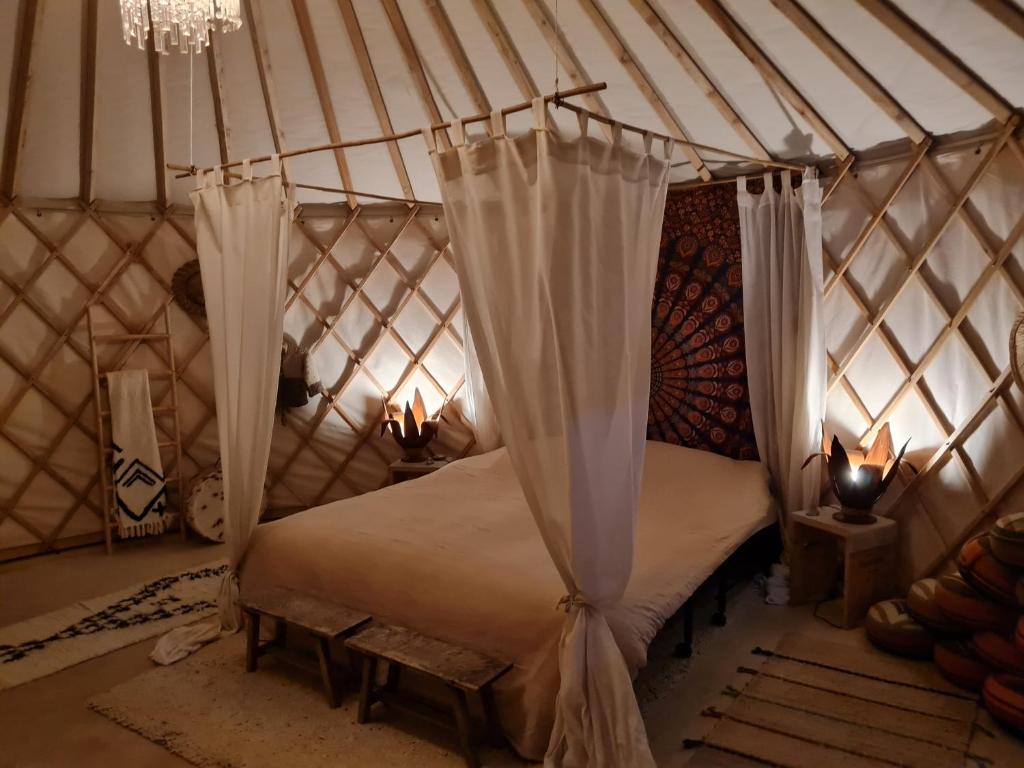 EckelradeVakantiewoning in monumentale boerderij met yurt的蒙古包内一间卧室,配有一张床
