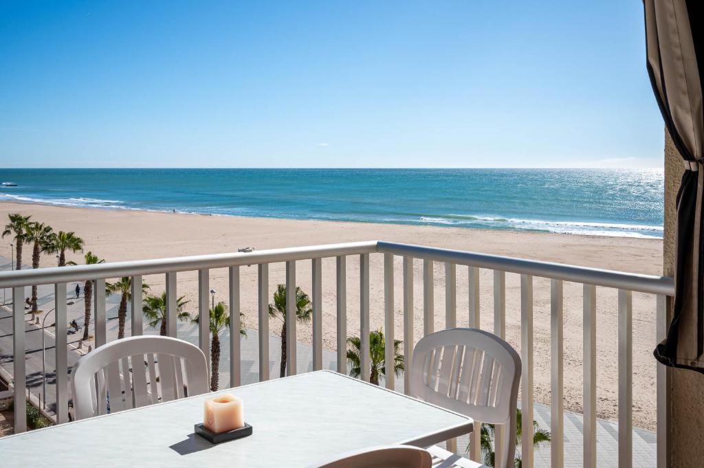 托里代巴拉AT020 Torremar I的一个带桌椅和海滩的阳台